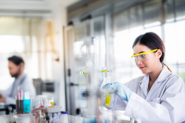 Wall Mural - attractive young asian scientist woman lab technician assistant analyzing sample in test tube at lab