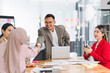 © kenchiro168 - Successful business people shaking hands during a meeting in the office.