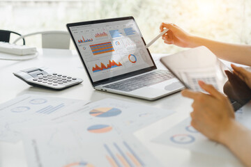 professional analyzing financial data graphs, charts on laptop display at a modern workspace. financ