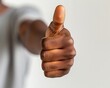 © CHONCHANOK PHOTO - Close-up of a person giving a thumbs up, confident expression, isolated white background, sign of approval, positive feedback, supportive gesture