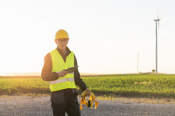 Poster - Engineer with digital tablet works on a field of wind turbines