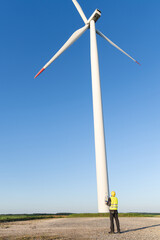 Poster - Engineer with digital tablet works on a field of wind turbines