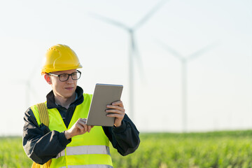 Poster - Engineer with digital tablet works on a field of wind turbines