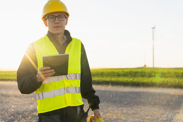 Poster - Engineer with digital tablet works on a field of wind turbines
