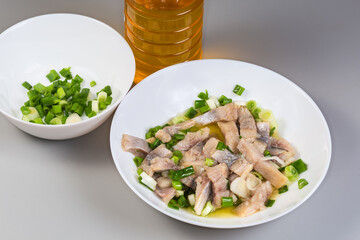 Wall Mural - Sliced pickled atlantic herring with chopped green onion on dish