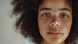 © Sunday Cat Studio - A woman with dark hair and a dark skin tone is looking at the camera, close up portrait