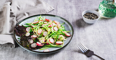 Poster - Fresh vitamin salad of cucumber and radish on a plate on the table web banner