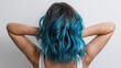 © Luluraschi - rear view of woman with wavy ombre blue dyed hair, white background