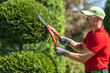 © Tomasz Zajda - Professional Landscaper Trimming Ornamental Shrubbery