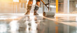 © oswasa - Construction worker using a roller to level a freshly poured concrete floor