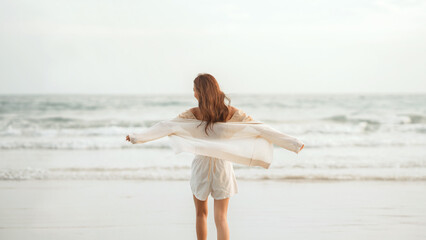Wall Mural - Rear view - Happy carefree young asian woman with freedom on the sea beach, Lady girl enjoying beach holiday, Summer beach vacation concept