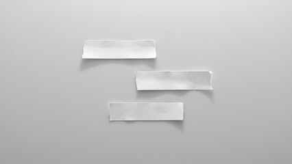 a close-up photo of three white torn paper notes on a gray background.