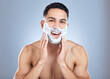 © peopleimages.com - Man, smile portrait and shaving foam for hair removal with skincare hygiene and face transformation in studio. Happy male person, dermatology and soap product for beard maintenance by gray background