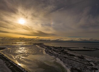 Wall Mural - A stunning winter sunset over a frozen lake with a jetty extending into the water