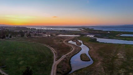 Sticker - A scenic aerial view of a coastal wetland at sunset with winding paths and water channels