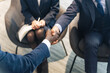 © metamorworks - Group of multinational business people shaking hands in a lobby