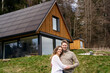 © Westend61 - Smiling couple embracing in front of modern house