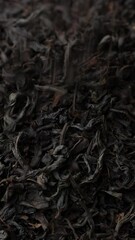 Poster - Heap of dried black tea leaves falling down in wooden bowl