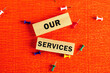 © Ihar - Copy space. Business and about our services concept. Words OUR SERVICES conceptual words on the wooden blocks . Beautiful orange background