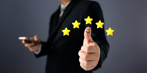 Customer service and poll concept. a businessman thumbs up on the happy smile icon and five star to give satisfaction in service.rating very impressed.