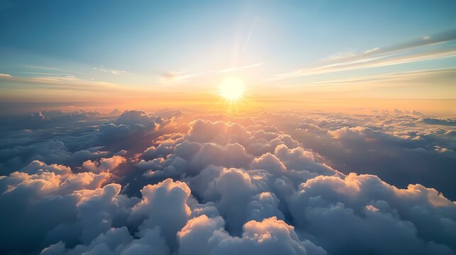 Amazing view of the fluffy clouds from above. The soft colors of the sunset create a truly mesmerizing scene.