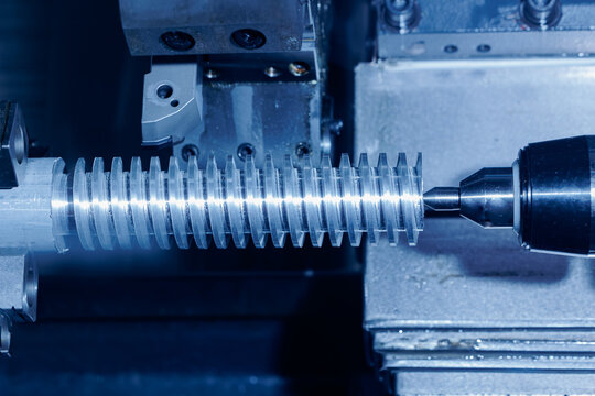 Processing of metal shaft part with threads on CNC lathe, tinted in blue