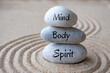 © Maurice Yom - Mind, body and soul text on zen stones with sand background