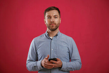 Wall Mural - Black smartphone in hands. Man is standing against background in the studio