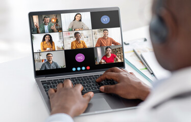 Poster - A man sits at a desk, his hands typing on a laptop keyboard, while participating in a video conference. The screen shows six participants in individual video frames.