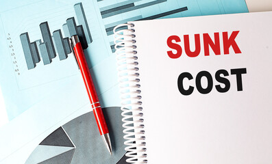 Poster - SUNK COST text on notebook on chart background