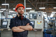 © standret - Confident facial expression. Factory worker is indoors with hard hat