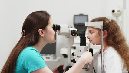 Wall Mural - Examination of the child using a slit lamp. Microscope and focused light source. A device for high-precision examination of the eye to determine the condition of the lens.