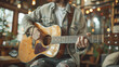 © aekkorn - Man practicing guitar in a cozy living room.