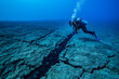 © fotogurmespb - A clear underwater fault line with visible tectonic plates and a diver during seismic activity