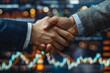 © Valentin - Two males shake hands near stock market screen