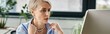 © LIGHTFIELD STUDIOS - A middle-aged businesswoman with short hair focuses intently on her laptop screen while working in an office setting.