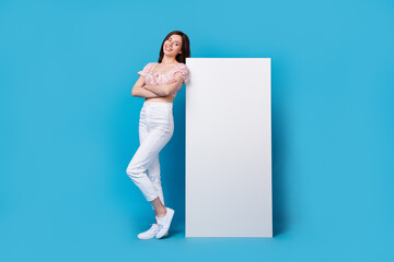 Wall Mural - Photo of lovely cute stylish lady arm folded stand big telephone device gadget look empty space board isolated on blue color background