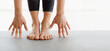 © Prostock-studio - Cropped of woman is seen performing a stretching exercise in a studio, with hands touching feet on a yoga mat. The focus is on flexibility and balance during a morning routine, panorama, copy space