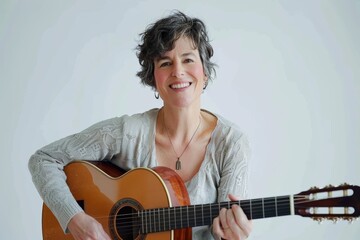 Poster - Portrait of a cheerful woman in her 40s playing the guitar on white background