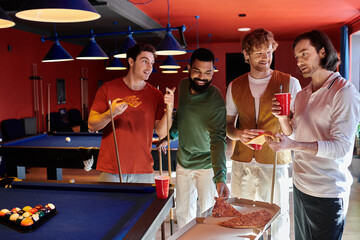 Wall Mural - A group of friends takes a break from their billiards game to enjoy pizza and drinks.