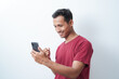 © Amjianto - a young man wearing a red t-shirt holding a cellphone is calling happy expression on an isolated white background