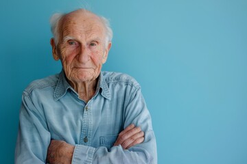 Wall Mural - Portrait of a satisfied caucasian elderly 100 years old man with arms crossed isolated on pastel blue background