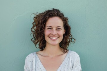 Wall Mural - Portrait of a smiling woman in her 30s smiling at the camera on pastel green background
