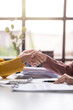 © Wasana - Two people shaking hands in front of a desk with papers and a calculator
