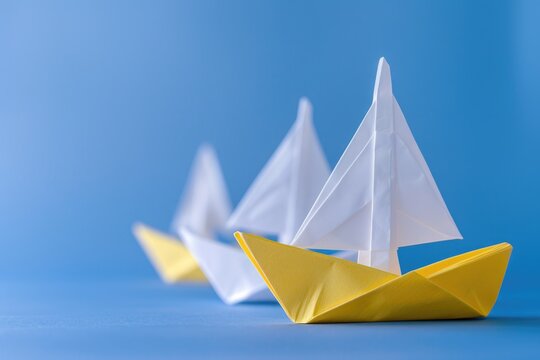 Yellow paper ship leads white ships on blue background.