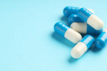 Wall Mural - Many antibiotic pills on light blue background, closeup. Medicinal treatment