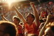 © Minerva Studio - Young man cheering with arms raised at soccer stadium