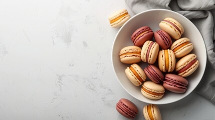 Wall Mural -  A bowl brimming with macaroons rests on a pristine white countertop Nearby, a gray-and-white towel is folded
