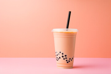 Cup of bubble tea on peach colored studio background