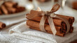 © SashaMagic - Bundle of cinnamon sticks tied with ribbon on white lace napkin